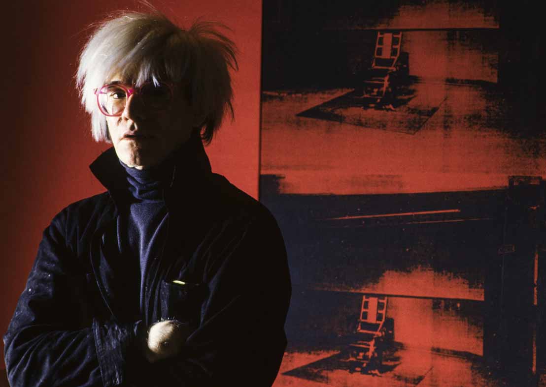 8_Alberto Venzago_Andy Warhol posiert vor dem Bild Little Electric Chair_1964 1965_Factory_Union Square West_New York_1984_copyright Alberto Venzago